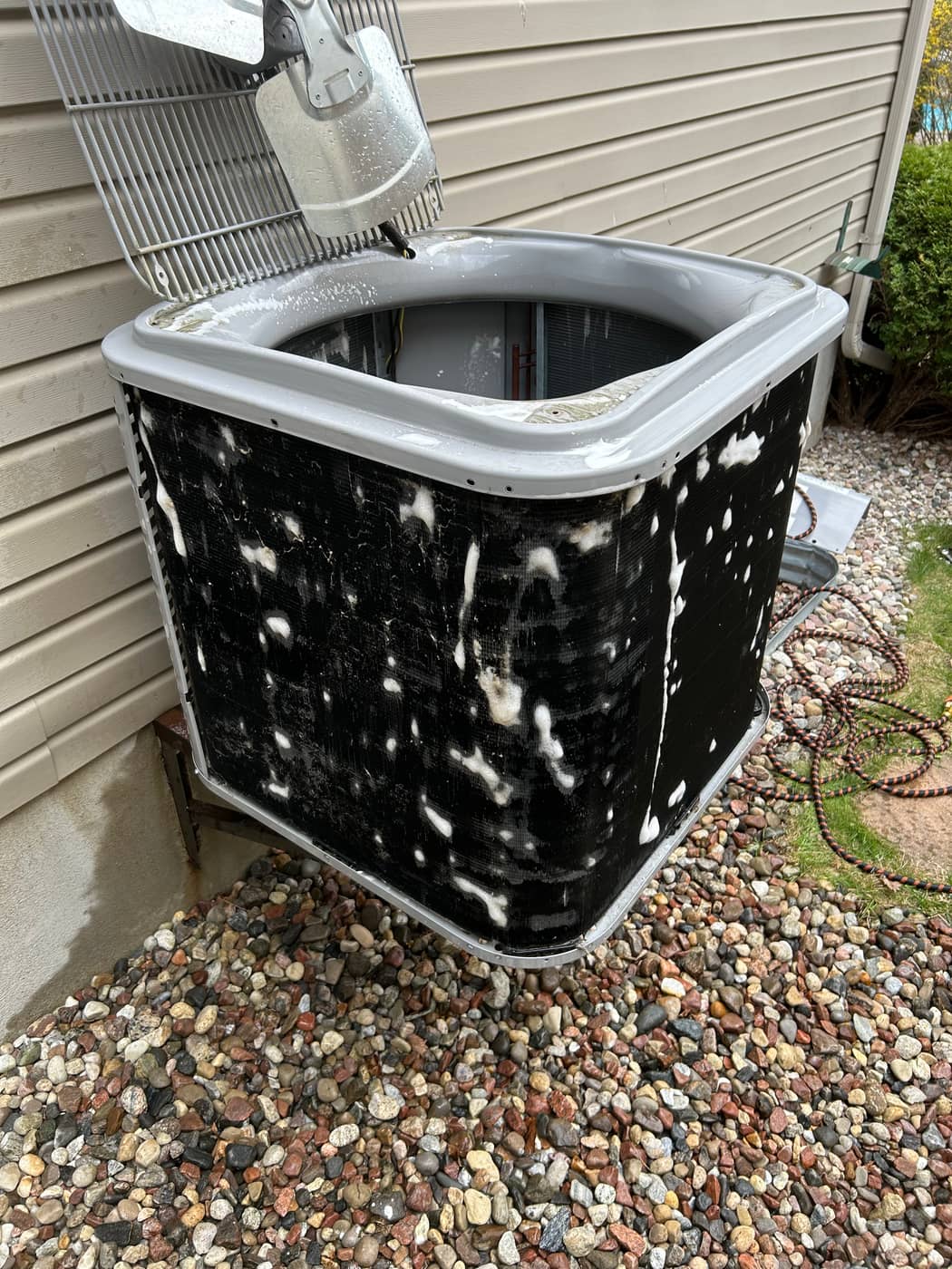 AC condenser coil being cleaned during a tune-up